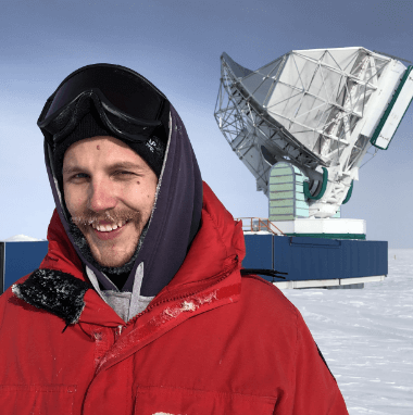 A man standing outside in a winter environment standing in front a satellite dish